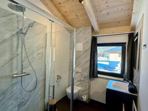 uma casa de banho com um chuveiro, um WC e um lavatório. em Chalet near Lake Pressegger and Nassfeld ski area em Hermagor