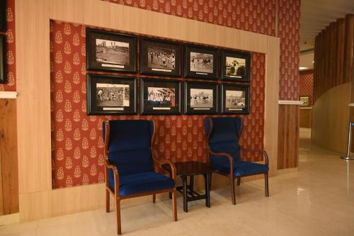 two blue chairs and a table in a hallway at Mayfair World Cup Village in Rourkela