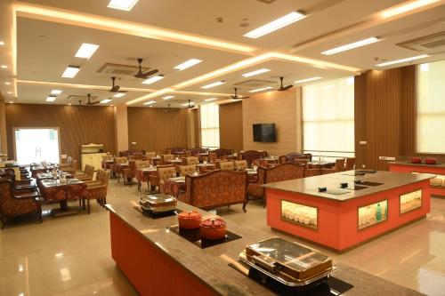 a dining room with tables and chairs in a restaurant at Mayfair World Cup Village in Rourkela