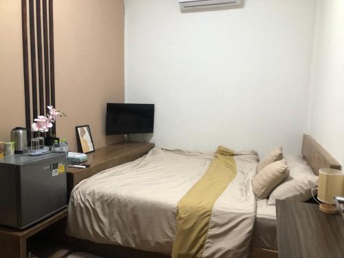 a small bedroom with a bed and a television at nine guesthouse in Ban Pa Tung (7)