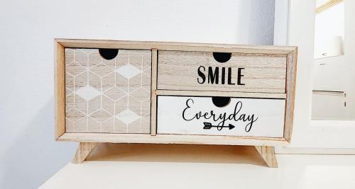 a wooden dresser with a smile everyday sign on it at Athens center cozy apartment near acropolis in Athens