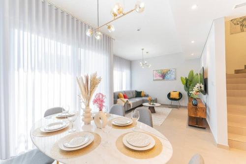 a white living room with a table and chairs at Cosy Luxury villa Tilal Alghaf in Dubai
