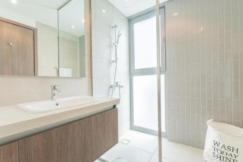 a bathroom with a sink and a glass shower at Cosy Luxury villa Tilal Alghaf in Dubai