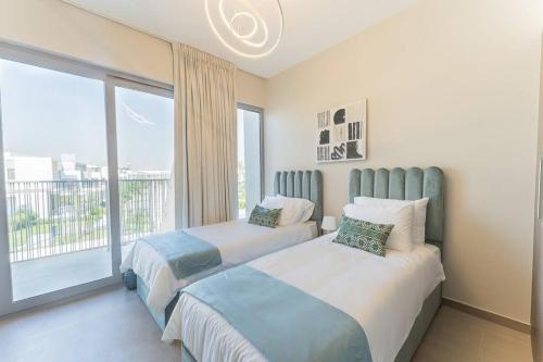 2 camas en un dormitorio con ventana grande en Cosy Luxury villa Tilal Alghaf en Dubái