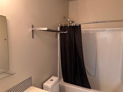 a bathroom with a shower with a black shower curtain at Entire 1-Bedroom Apartment In Downtown Portland in Portland