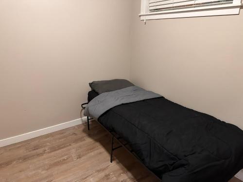 a small bedroom with a black bed in the corner at Entire 1-Bedroom Apartment In Downtown Portland in Portland