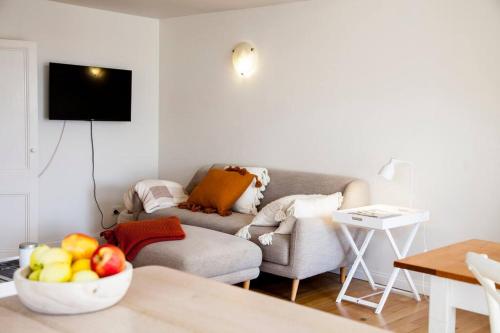 a living room with a couch and a bowl of fruit at Writer's Cottage, luxurious oasis in the heart of North Hobart in Hobart