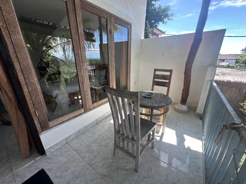 a chair and a table on a balcony at Azona Greens Uluwatu in Uluwatu