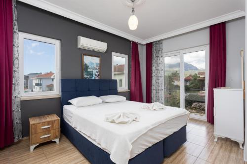 1 dormitorio con 1 cama azul y ventanas en Villa Magnolia, en Dalyan