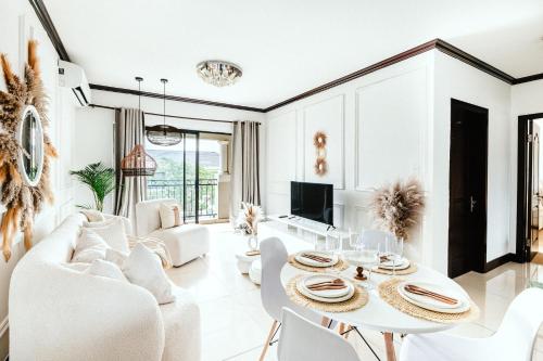 uma sala de estar com mobiliário branco e uma mesa e cadeiras em Bali Dream-Luxury Apartment-Power Backup em Sandton