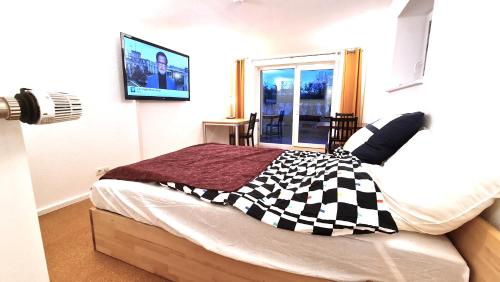 a bedroom with a bed with a checkered blanket at Zentral, ruhig ggü. Uni (ENC), 5min zum Bahnhof und zur Autobahn in Siegen