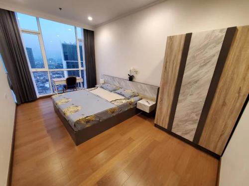 a bedroom with a bed and a large window at Supalai Bangkok in Bangkok