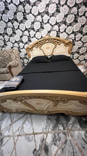 a bed in a room with a black and gold at Чистая и уютная квартира в 6-ом микрорайоне in Taraz