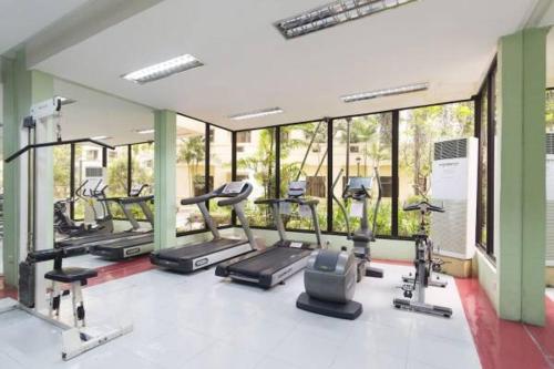 a gym with a bunch of treadms and machines at Homey & Stylish 2BR @ Burgos Circle, BGC, Taguig in Manila