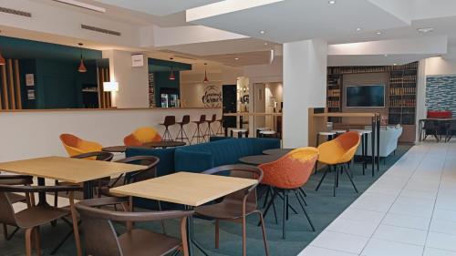 a restaurant with tables and chairs and a bar at Holiday Inn Express Lille Centre, an IHG Hotel in Lille