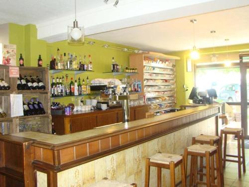 a restaurant with a bar with stools and bottles of alcohol at AUX GLOBE-TROTTERS in Murat