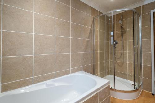 a bathroom with a shower and a bath tub at 52 Carr Avenue in Leiston