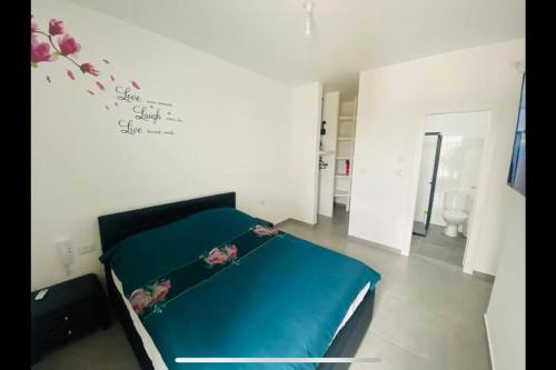 a bedroom with a bed with a blue sheets at New- Luxury Glil Yam For Family 4 Rooms Parking in Herzliya