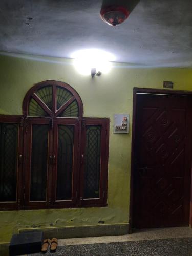 Zimmer mit zwei Türen und Schuhen auf dem Boden in der Unterkunft Vrindavan Home Stay,Varanasi. in Varanasi