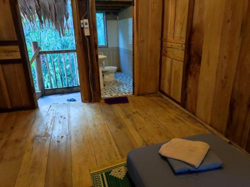 a room with a bed and a door to a bathroom at Le Pont Mu Waterfall Homestay in Ải Hạ