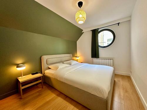 - une chambre avec un grand lit blanc et une fenêtre dans l'établissement My Little Home - Le Liberté 47, à Lille