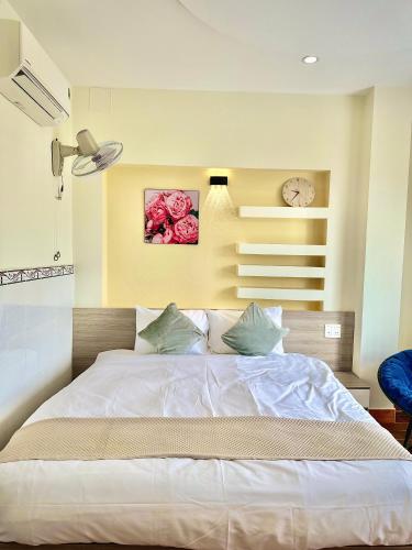 a bedroom with a large white bed with flowers on the wall at Khách sạn Sinh Hiền in Liên Trì (4)