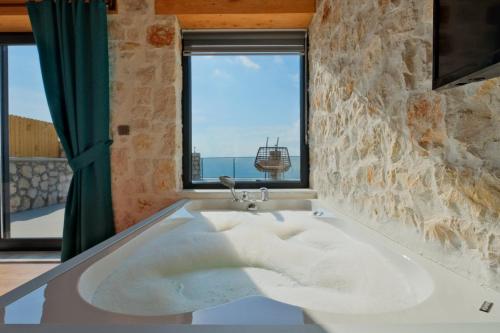 a large bath tub in a room with a window at Villa Tasila 2 