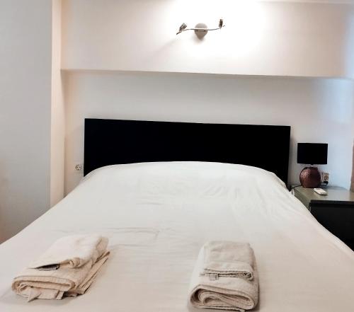 - une chambre avec un lit blanc et des serviettes dans l'établissement Beautiful cozy apartment, à Athènes