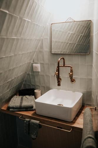 une salle de bain avec un lavabo blanc et un miroir dans l'établissement Maison d'hôtes Bel Estiu, à Saint-Geniès