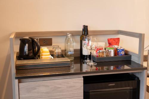 a counter with wine glasses and wine bottles on it at NH Bangkok Sukhumvit Boulevard in Bangkok
