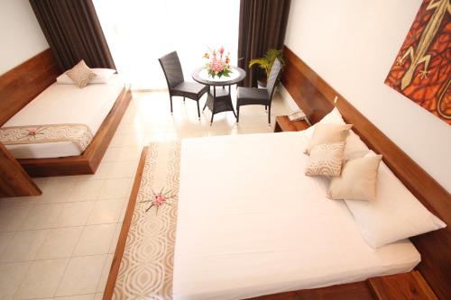 a room with two beds and a table and chairs at The Melanesian Port Vila in Port Vila