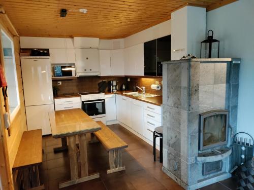 a kitchen with a table and a fireplace in it at Himos Slalom 1, Poreallas kuuluu hintaan in Jämsä