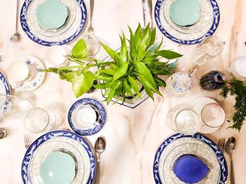 a table with blue plates and a vase with a plant at Mossy Forest Family Retreat II, 2-8 pax, Cameron Highlands in Cameron Highlands