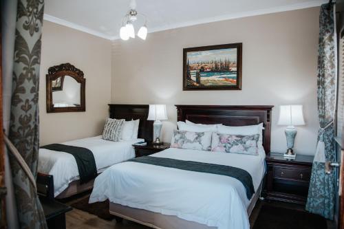 a hotel room with two beds and a mirror at The Symphony Guest House in Queenstown