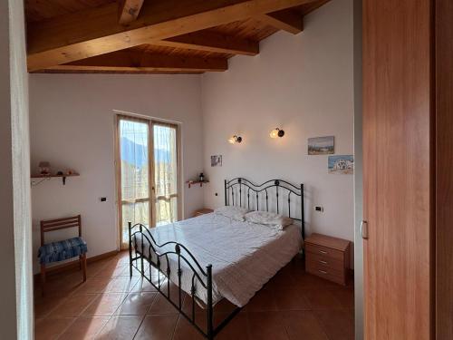 sypialnia z łóżkiem i dużym oknem w obiekcie Apartment with balcony and garage Dongo - Larihome A48 w mieście Dongo