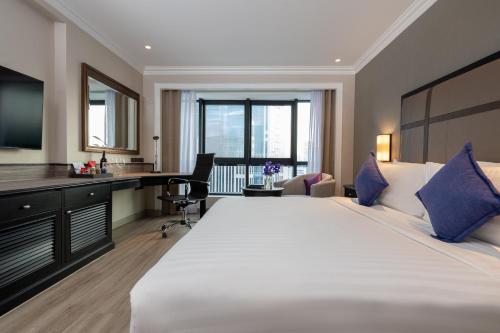 a hotel room with a large bed and a desk at NH Bangkok Sukhumvit Boulevard in Bangkok