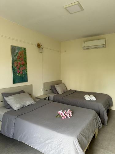 two beds in a room with flowers on them at Ginger Sihanoukville in Sihanoukville