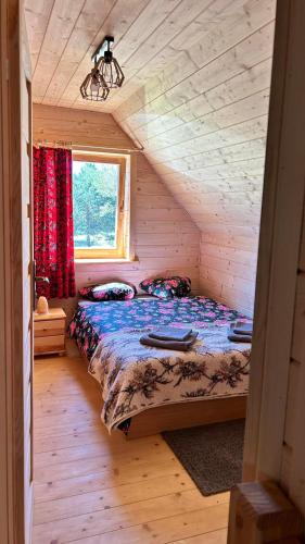 a bedroom with a bed in a log cabin at Ośrodek u Polaka-domek góralski in Radkowice