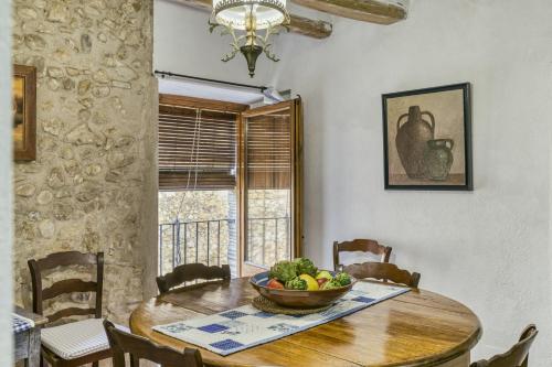 a dining room table with a bowl of fruit on it at Can Roca in Montiró
