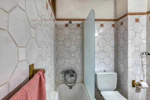 a bathroom with a white tub and a toilet at Can Roca in Montiró