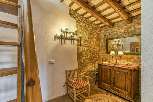 een badkamer met een wastafel, een stoel en een spiegel bij Can Roca in Montiró