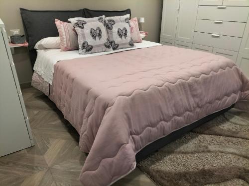 ein rosa Bett mit Kissen und einer rosa Decke in der Unterkunft Casa Bella Napoli Sanità in Neapel