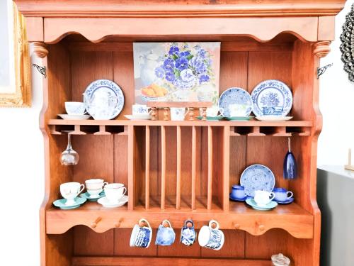 a wooden shelf with blue and white dishes on it at Mossy Forest Family Retreat II, 2-8 pax, Cameron Highlands in Cameron Highlands