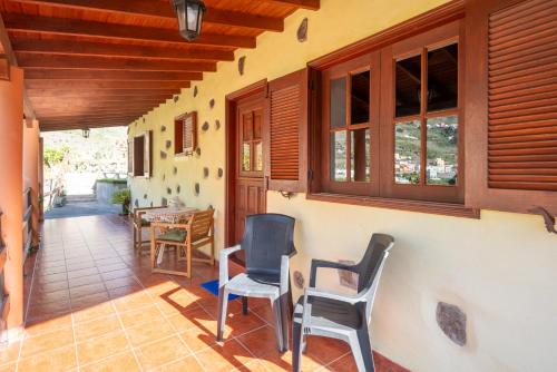 a porch of a house with chairs and a table at Casa Rural Nuevitas I in Hermigua
