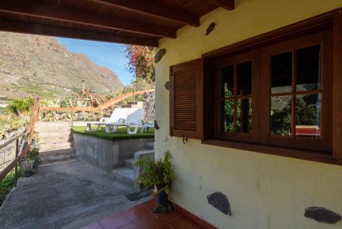 a house with a window and a view of a mountain at Casa Rural Nuevitas I in Hermigua