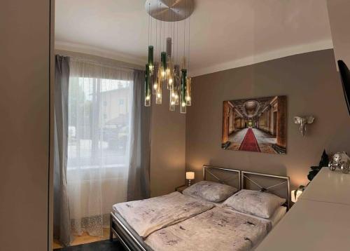 Schlafzimmer mit einem Bett und einem Kronleuchter in der Unterkunft Haus Schmidhuber Wohnung 1 in Grossgmain