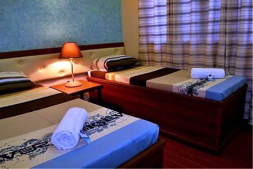sypialnia z 2 łóżkami i stołem z lampką w obiekcie Julieta's Pension House w mieście Puerto Princesa