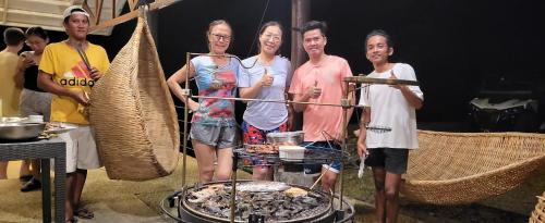 a group of people standing in front of a grill at Aquaventure Reef Club in Mabini