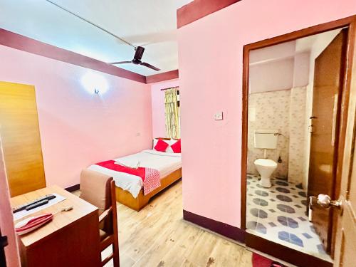 Habitación pequeña con cama y baño. en Hotel Green Orchid, en Katmandú