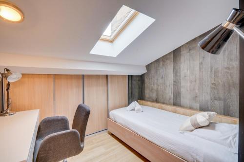 une chambre avec un lit, un bureau et une fenêtre dans l'établissement Le Particulier - Centre ville de Bordeaux, à Bordeaux